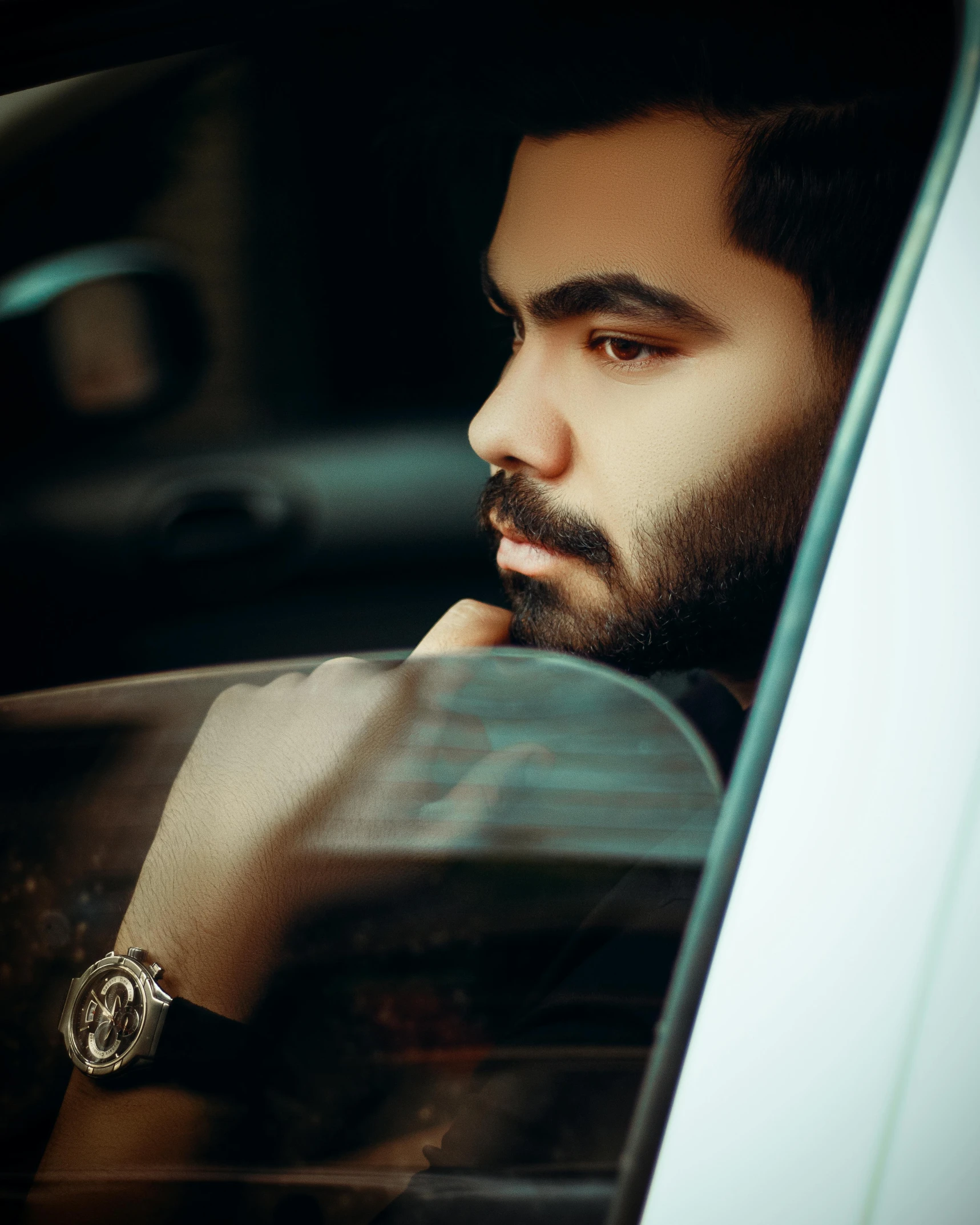 a man is sitting in a car with his hand on his head