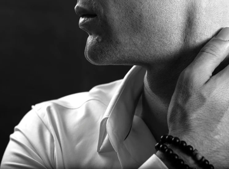 a black and white po of a person adjusting their collar