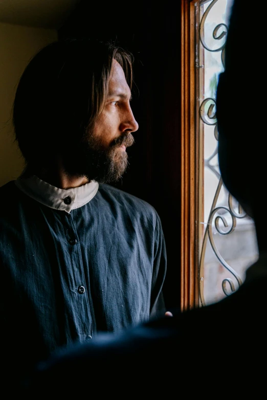 a bearded man looking into the window