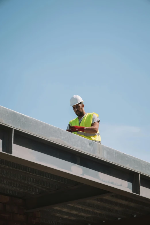 a man on a bridge fixing soing on top of him