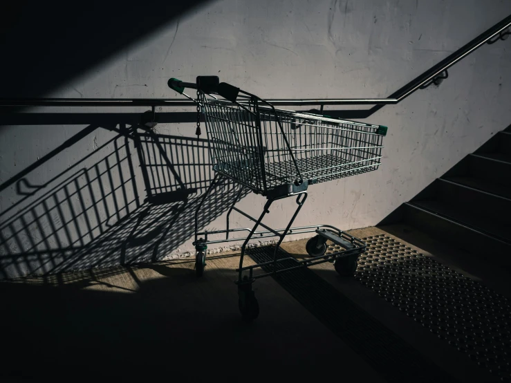 an empty shopping cart sits outside on the concrete floor