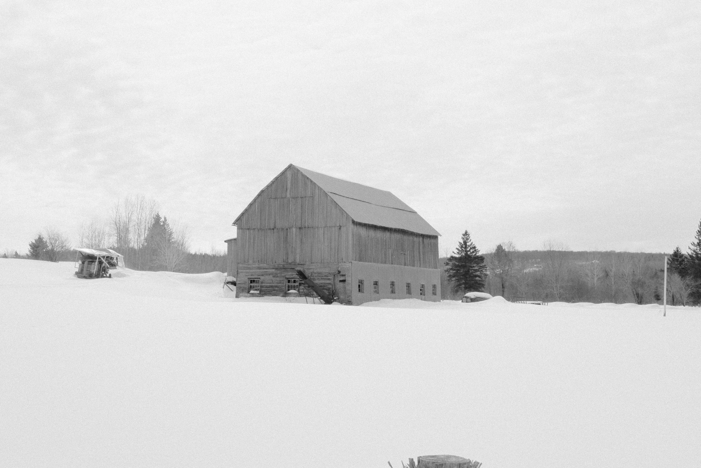 a farm building with multiple windows in the winter