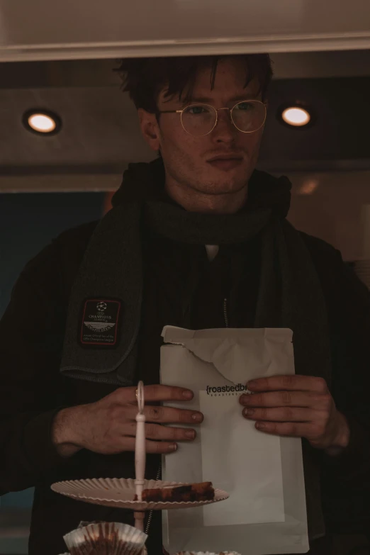 a man is wearing a brown jacket and holding a birthday candle