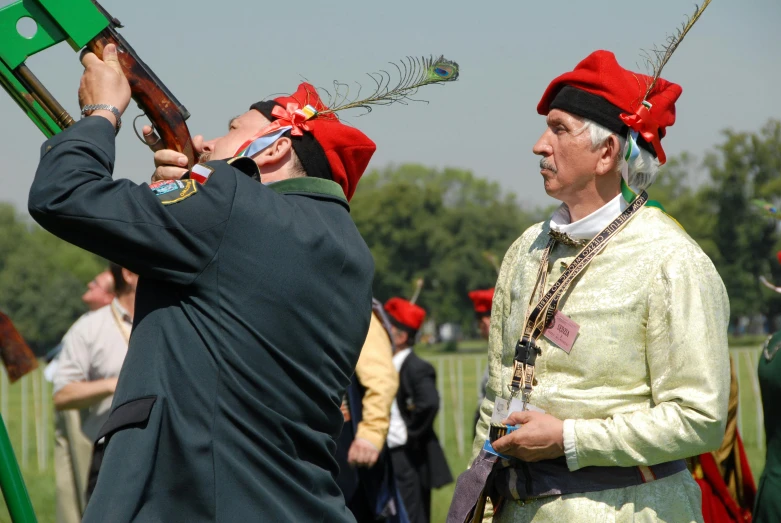 men with wooden weapons in costume at an event