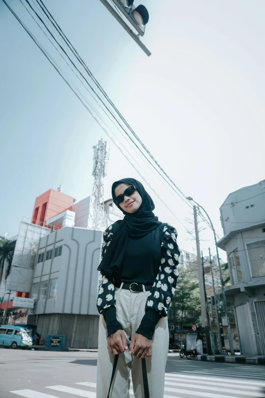 a woman walking down a street while wearing a hijab