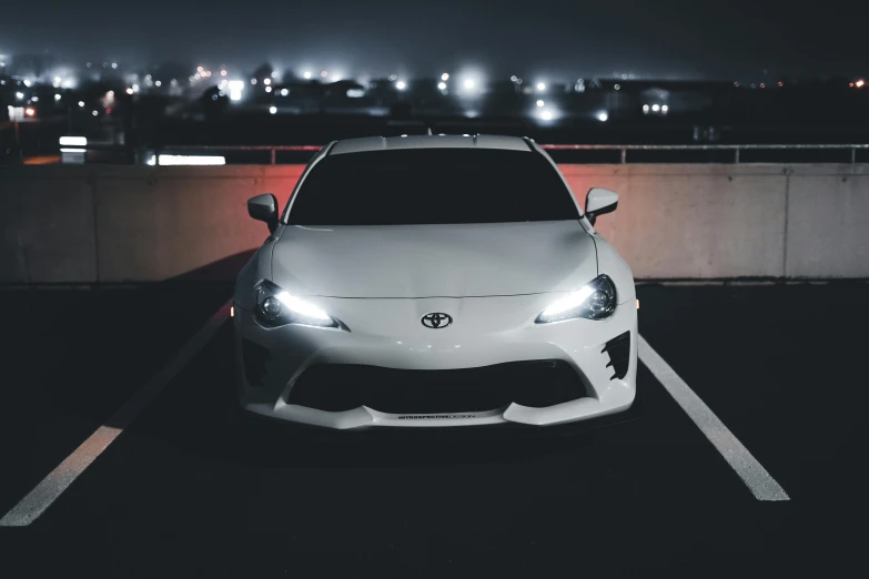 toyota sports sedan in a parking lot at night