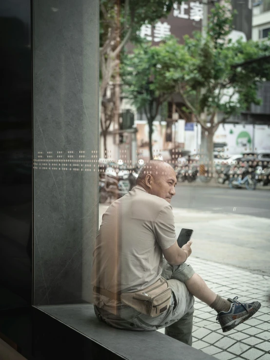 a man sitting on a bench with his leg up to the window