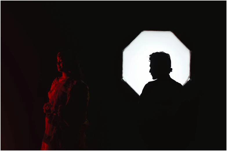 a man and woman stand in front of an inverted light