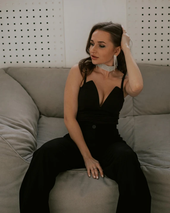 a woman wearing black is sitting on the couch