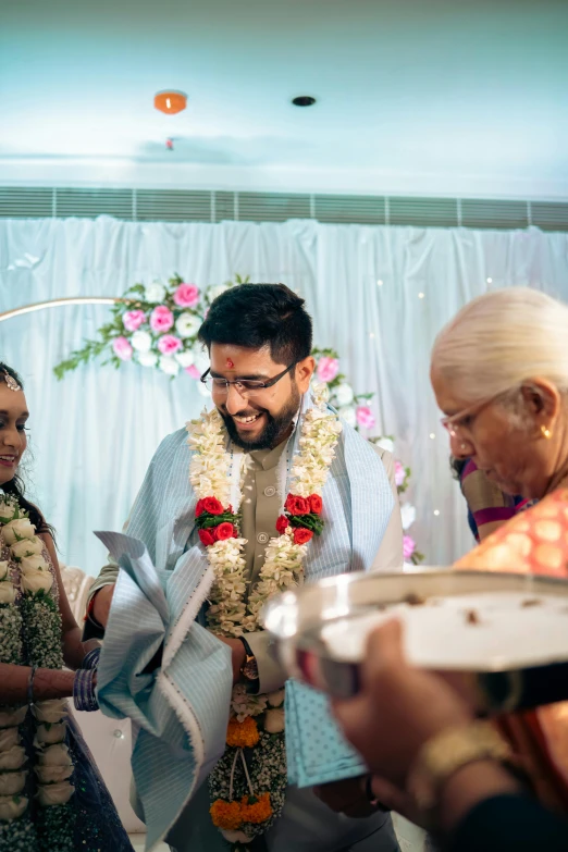 a man is smiling while he stands with two women