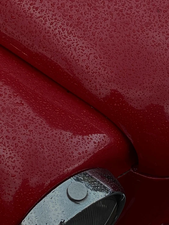 a close up of the front end of a red car