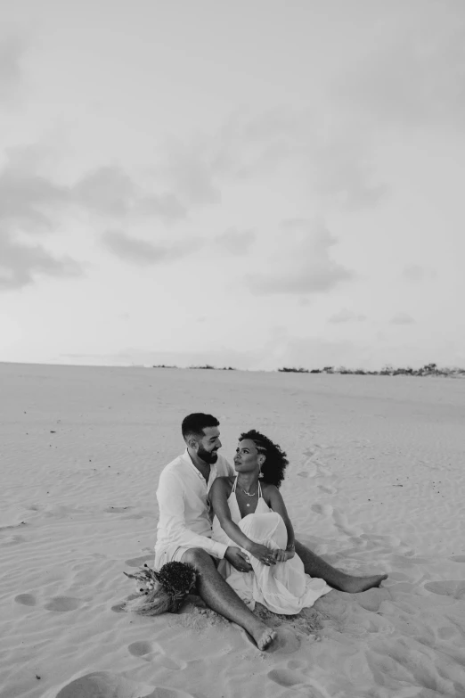 black and white image of two people on the beach