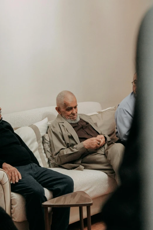 two older men sitting on the sofa talking