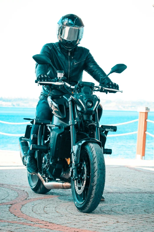 a person in black jacket and helmet sitting on a motorcycle