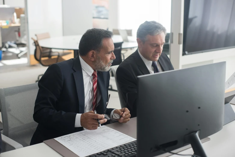 two businessmen working on their computer at the office