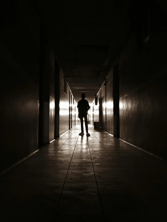 a person standing in an empty hallway