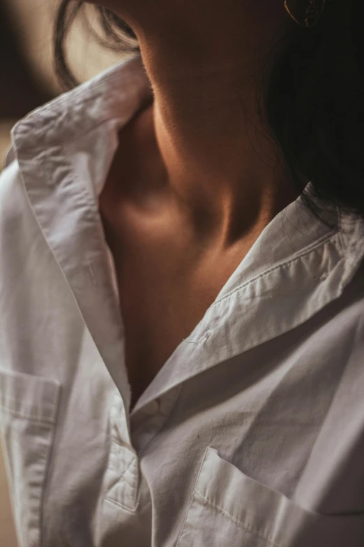 a woman wearing a white shirt has an unusually shaped object in her nose