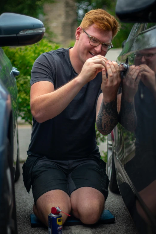 a man is looking into the door window of his car