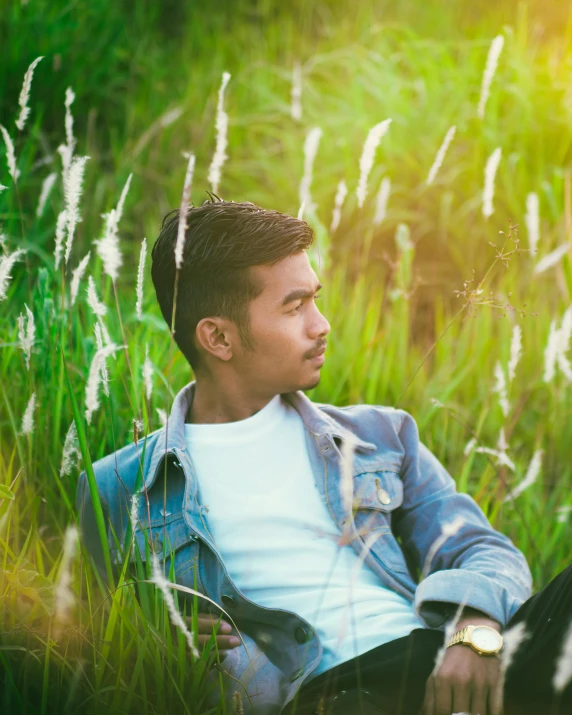 a man sitting in the grass looking off to the side