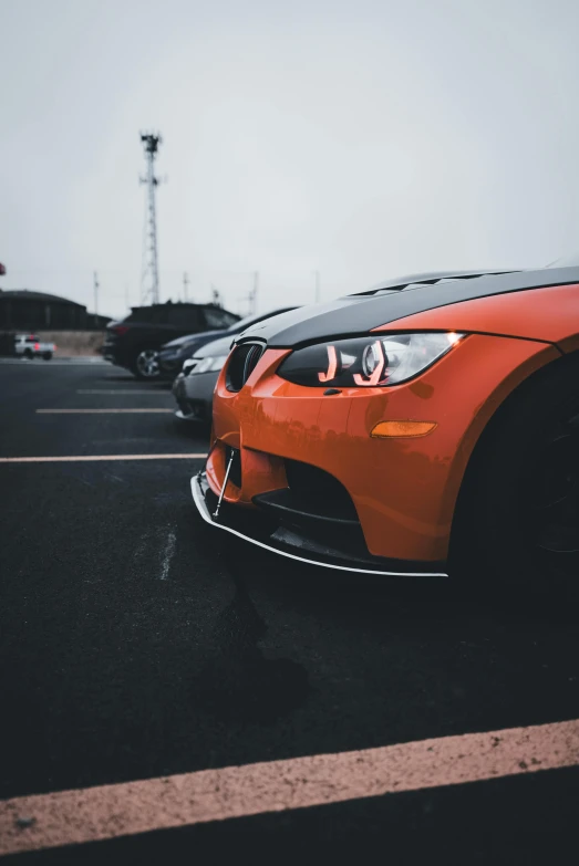 a red sports car with a black hood parked in a lot