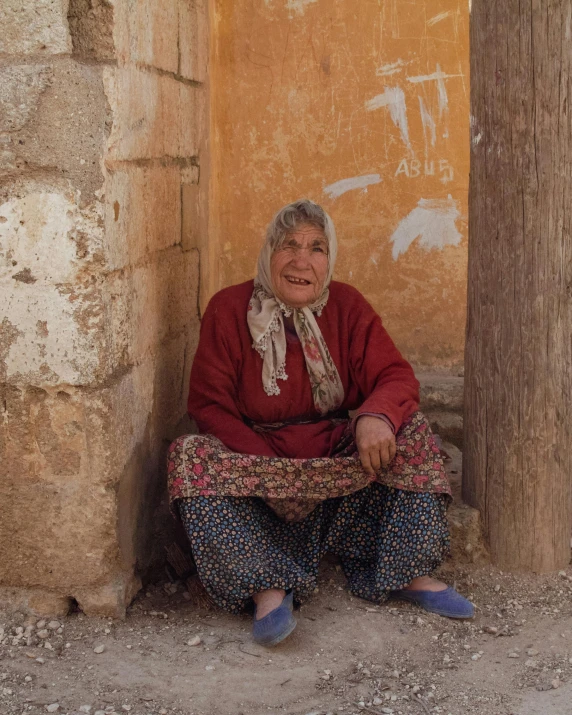 a woman is sitting outside by the side of the building