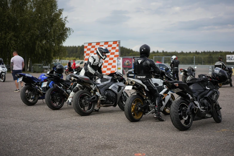 three people and motorcycles in a parking lot