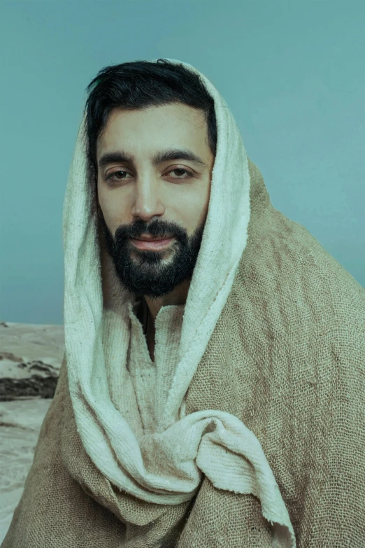 man in a hooded robe on the beach