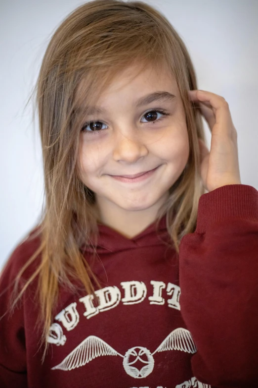 a little girl that is smiling with long blonde hair