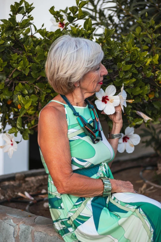 a woman sitting down and holding flowers in her hands