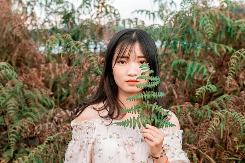 a beautiful young woman holding onto a plant