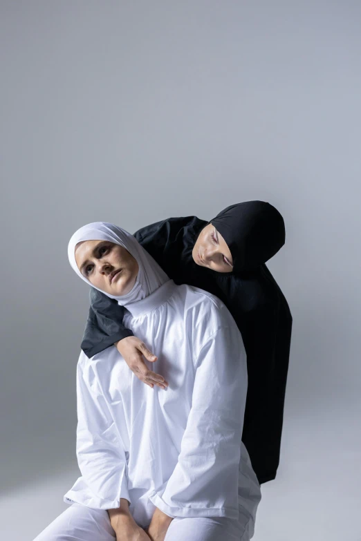 two people wearing headscarves one carrying another