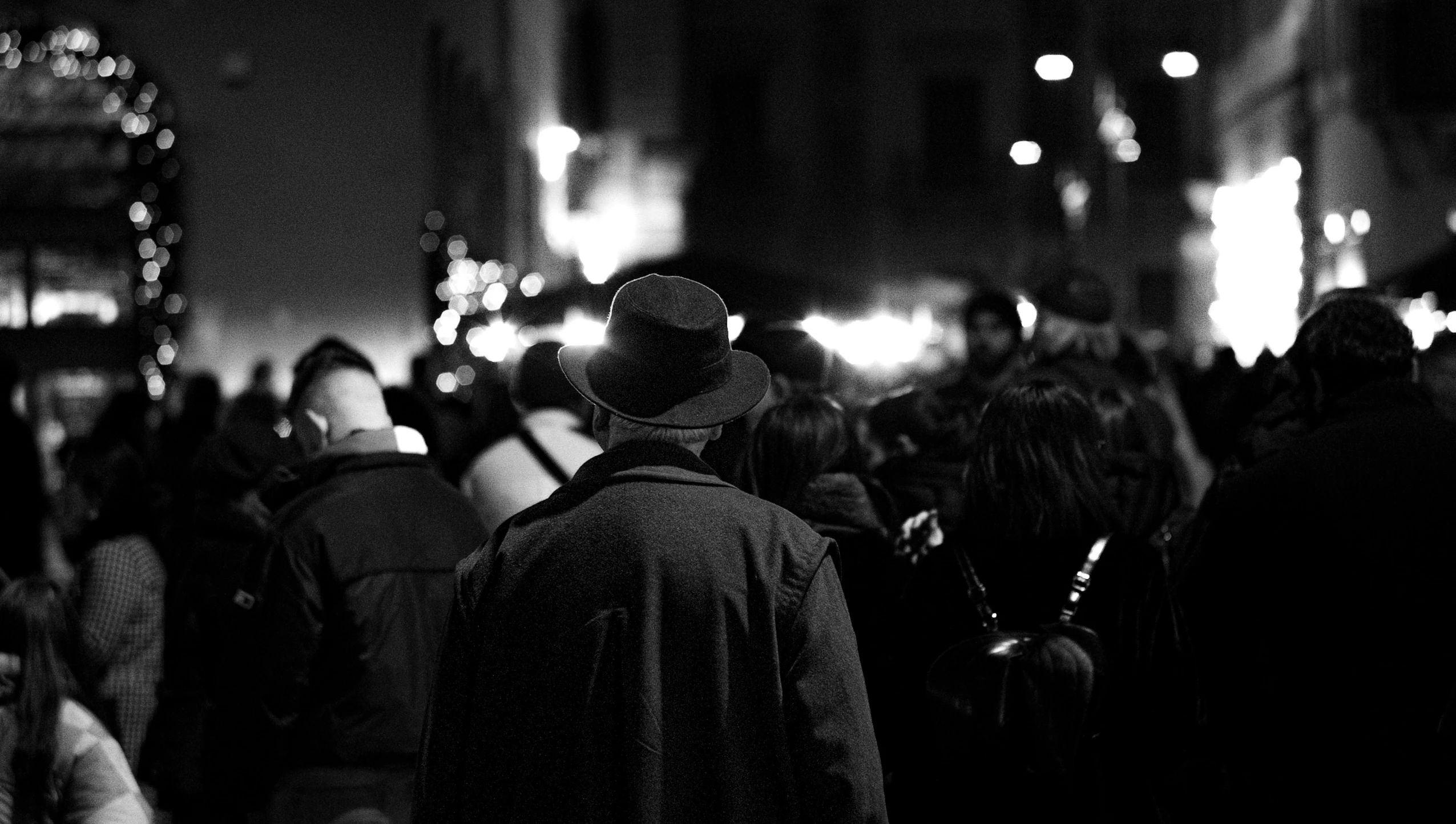 a crowd of people standing next to each other on a sidewalk