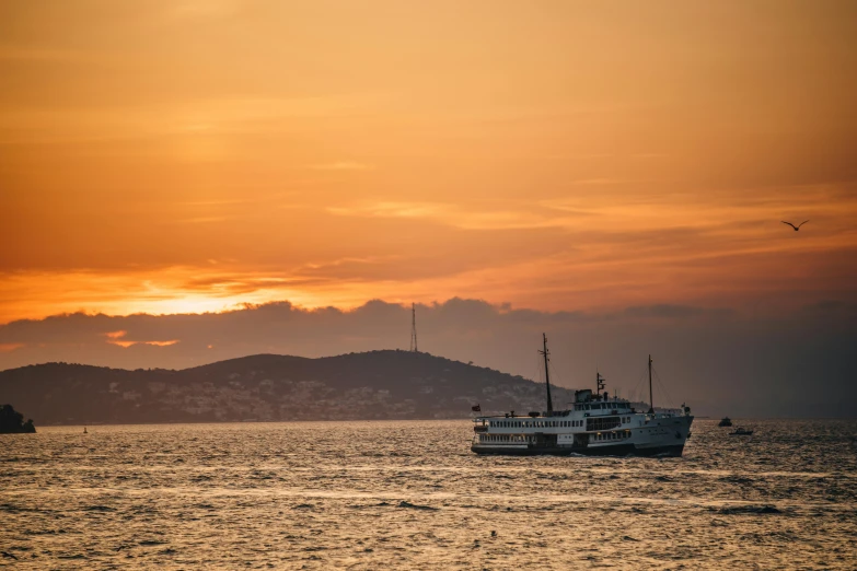 a ship in the middle of an ocean at sunset