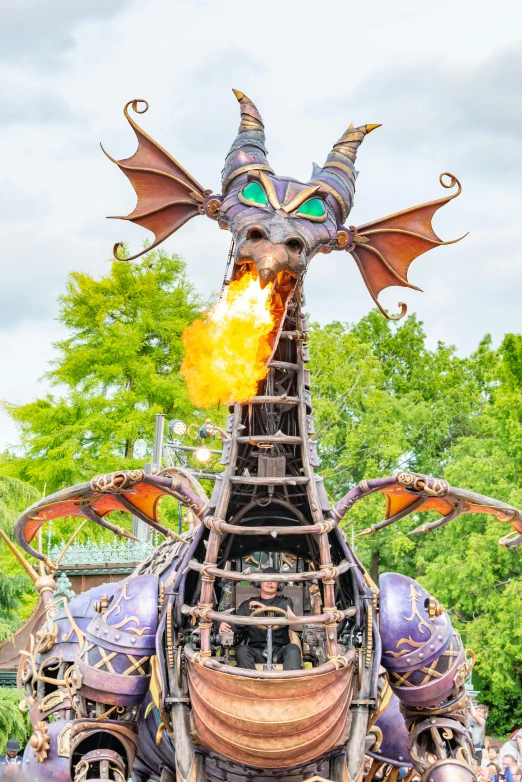the sculpture of a dragon is burning with many smaller wheels