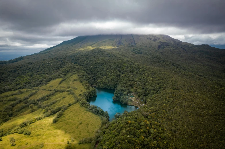 an aerial view of a tree - covered mountain range, lake and forest