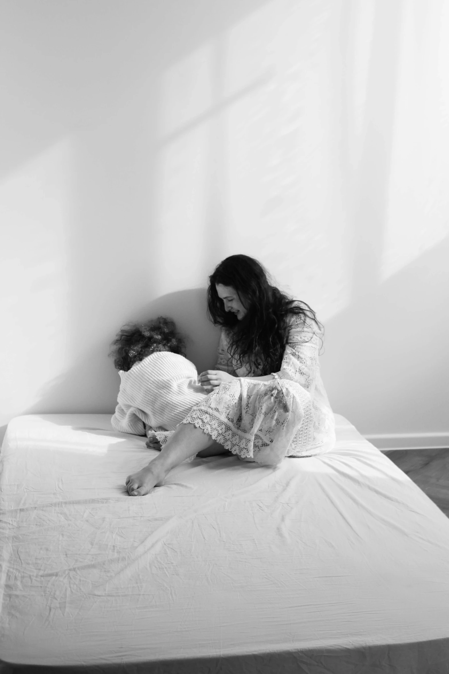 there is a woman and a child sitting on a bed