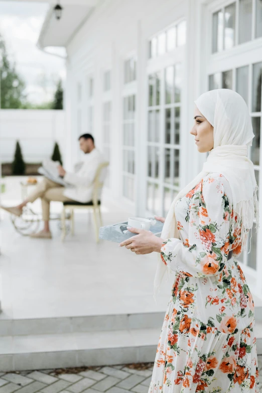 a young woman standing by the window in her house