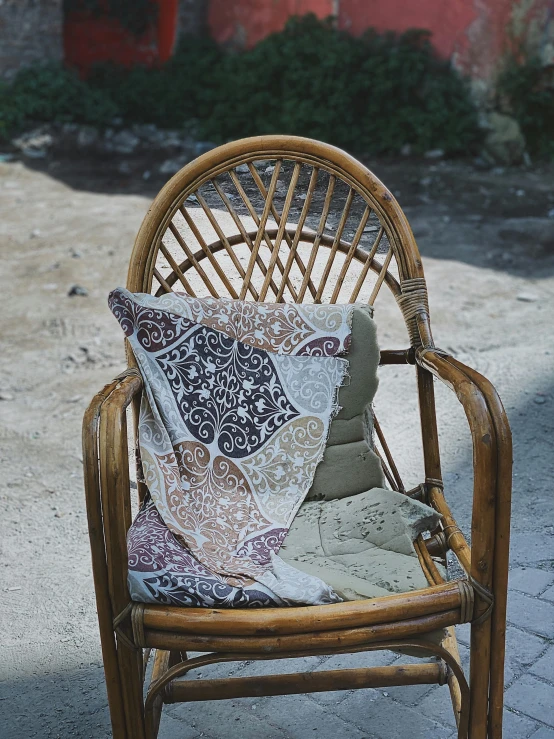 a chair with a cushion on it is sitting on the sidewalk