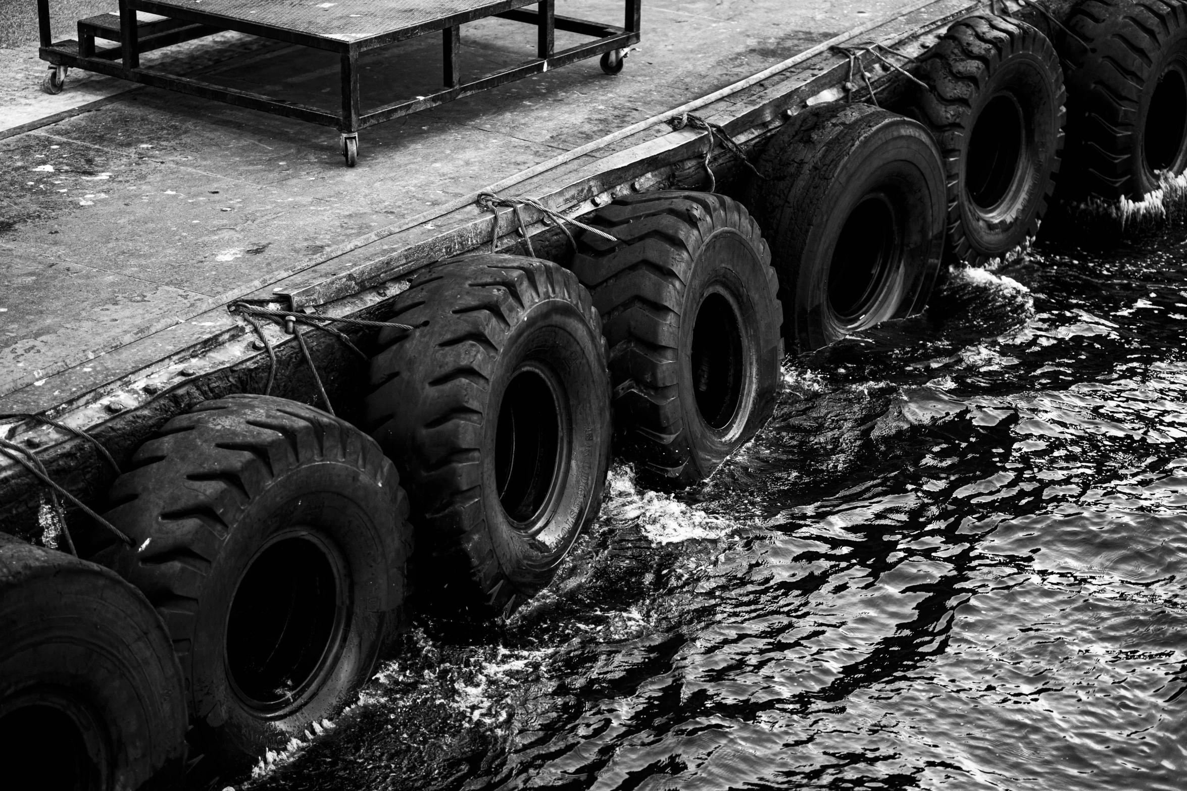 a long truck on a tow boat carrying tires