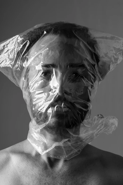 a man wrapped in plastic holding soing over his head