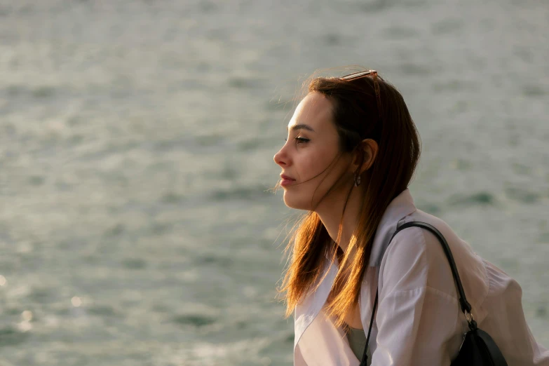 a beautiful woman sitting in front of the water