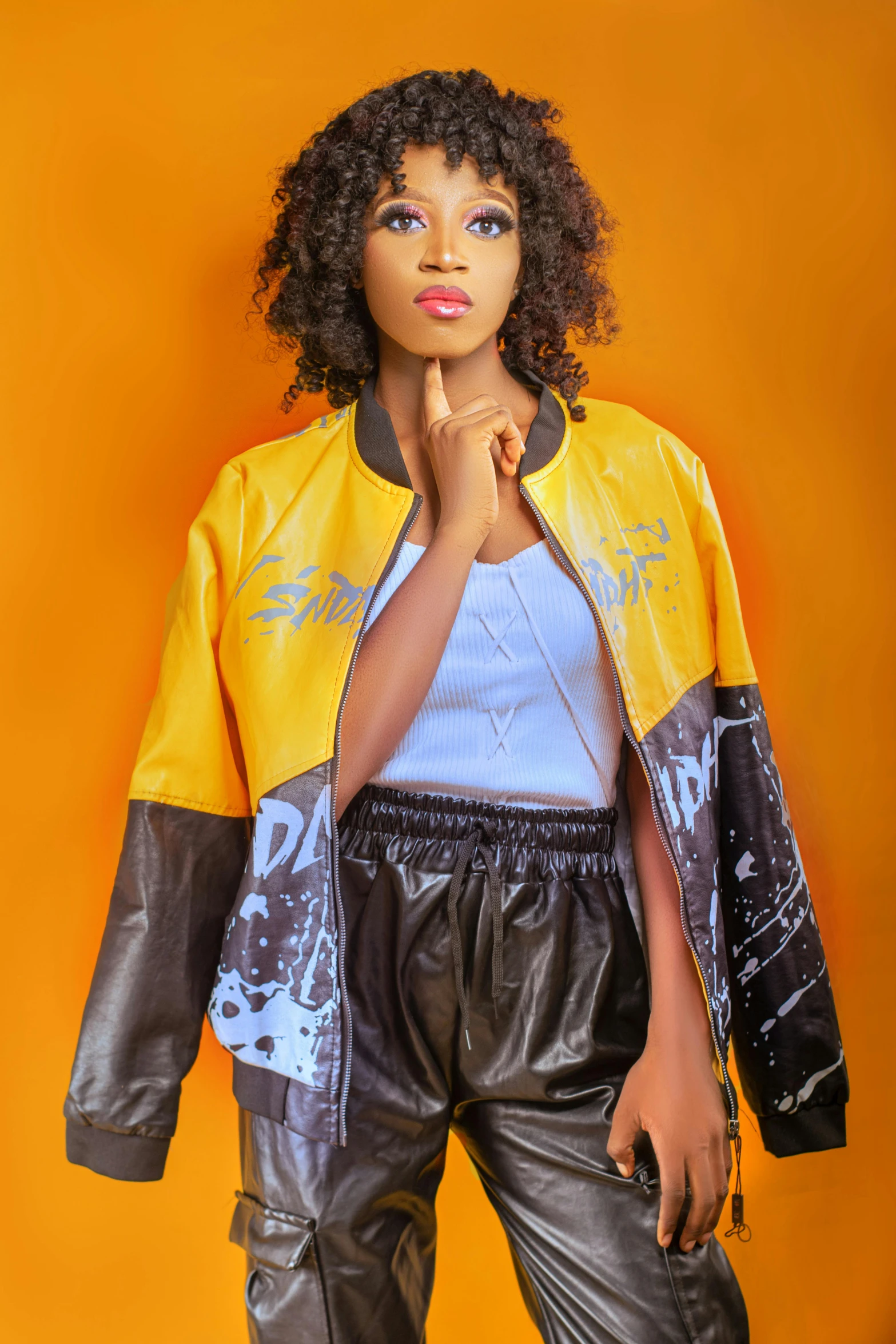 a  with afro hair posing in black and yellow