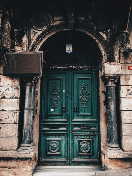 the entrance to an old, worn - down building with stone columns