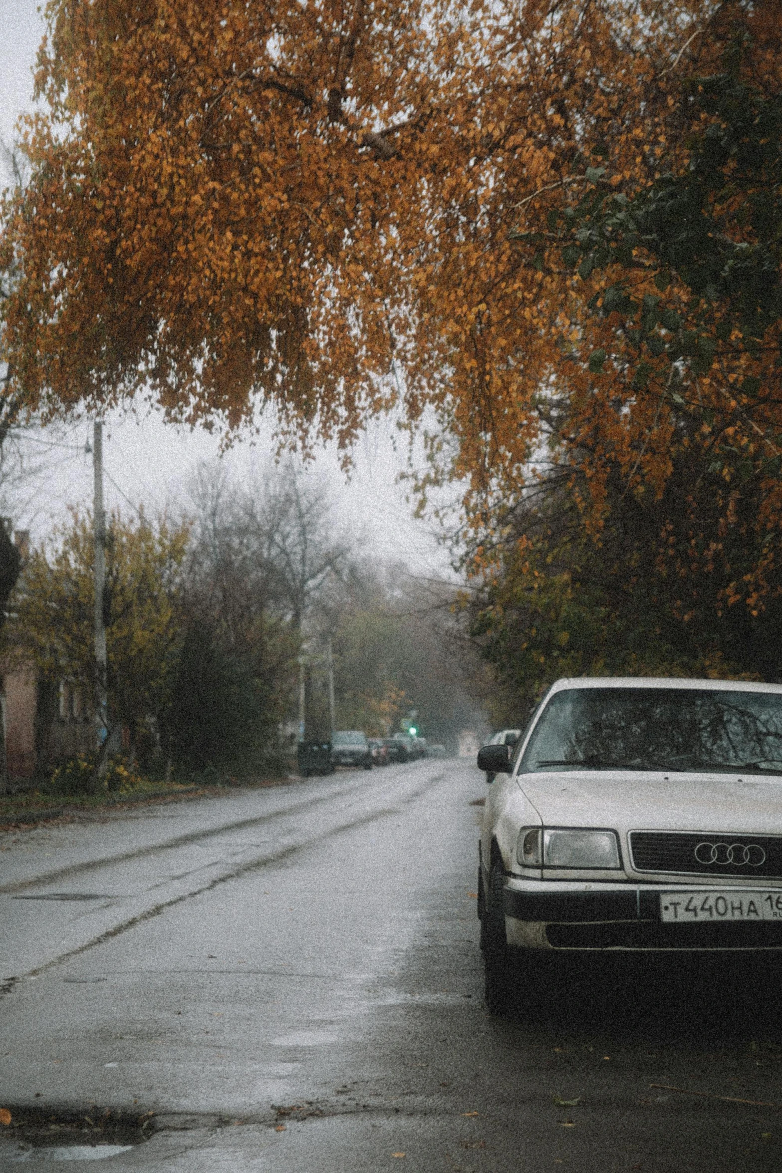 a car is stopped on the side of the street during a heavy rain