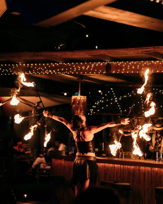 a woman is standing by some fire lights