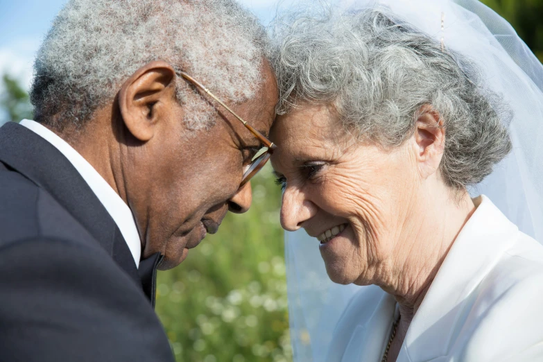 an elderly couple are smiling at each other