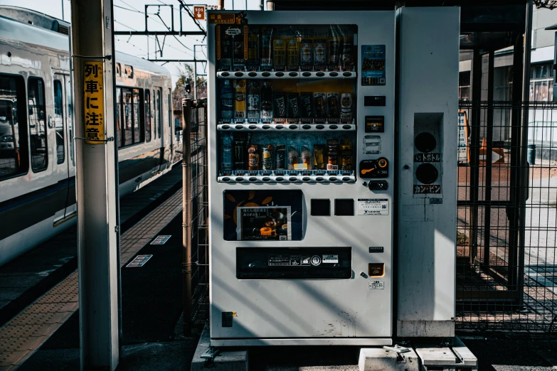 a large white machine sitting next to a train