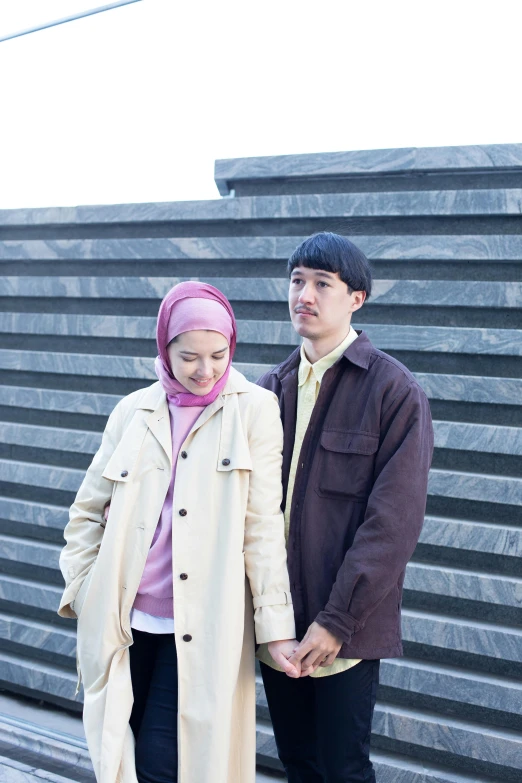 a young couple stands on steps posing for the camera