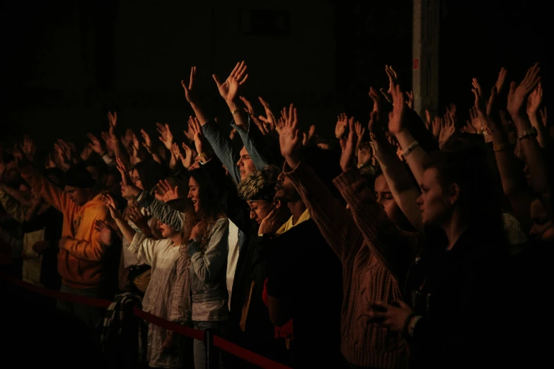 a crowd of people raising their arms in the air