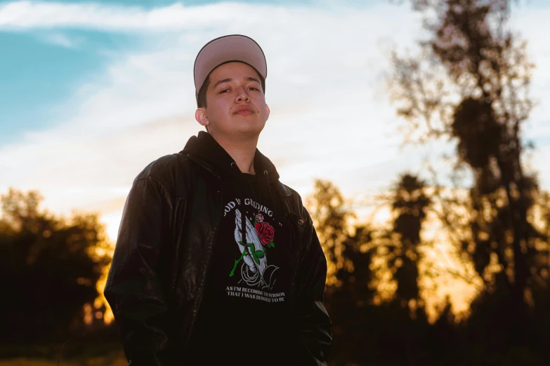 a person standing next to a tree at sunset